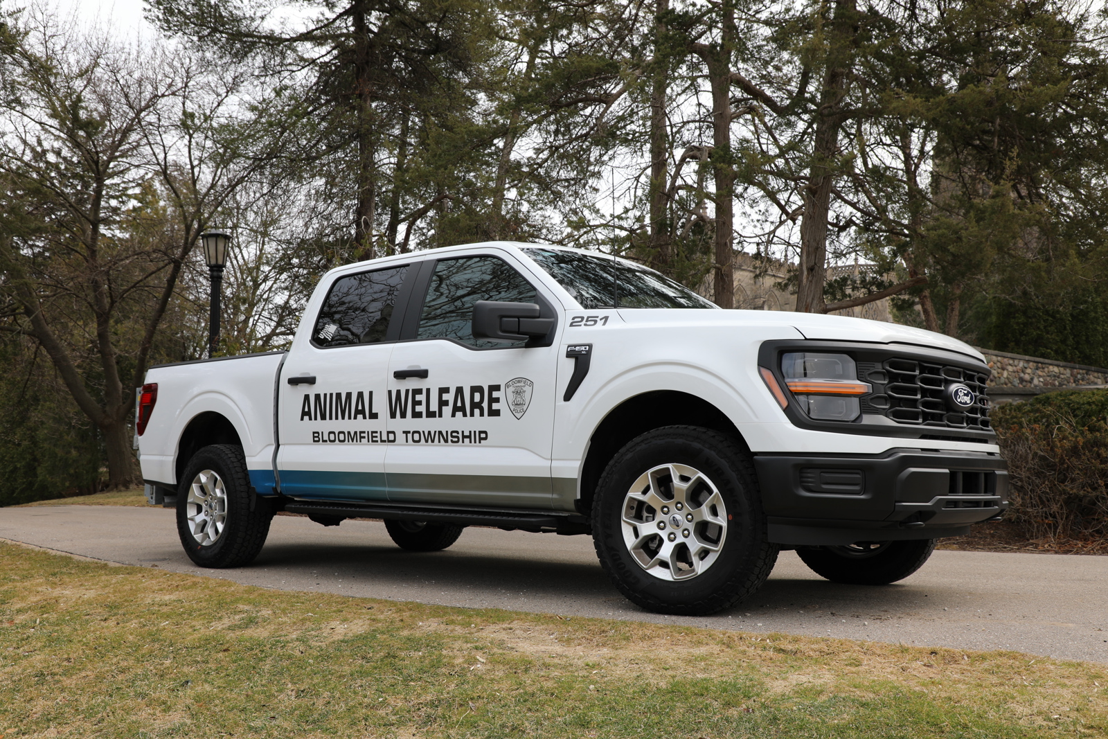 White Animal Welfare Truck side profile with tree background