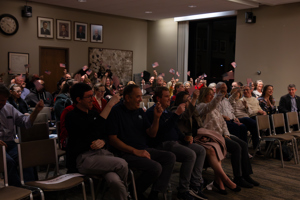 More of the audience at Township Hall smiling and waving American flags
